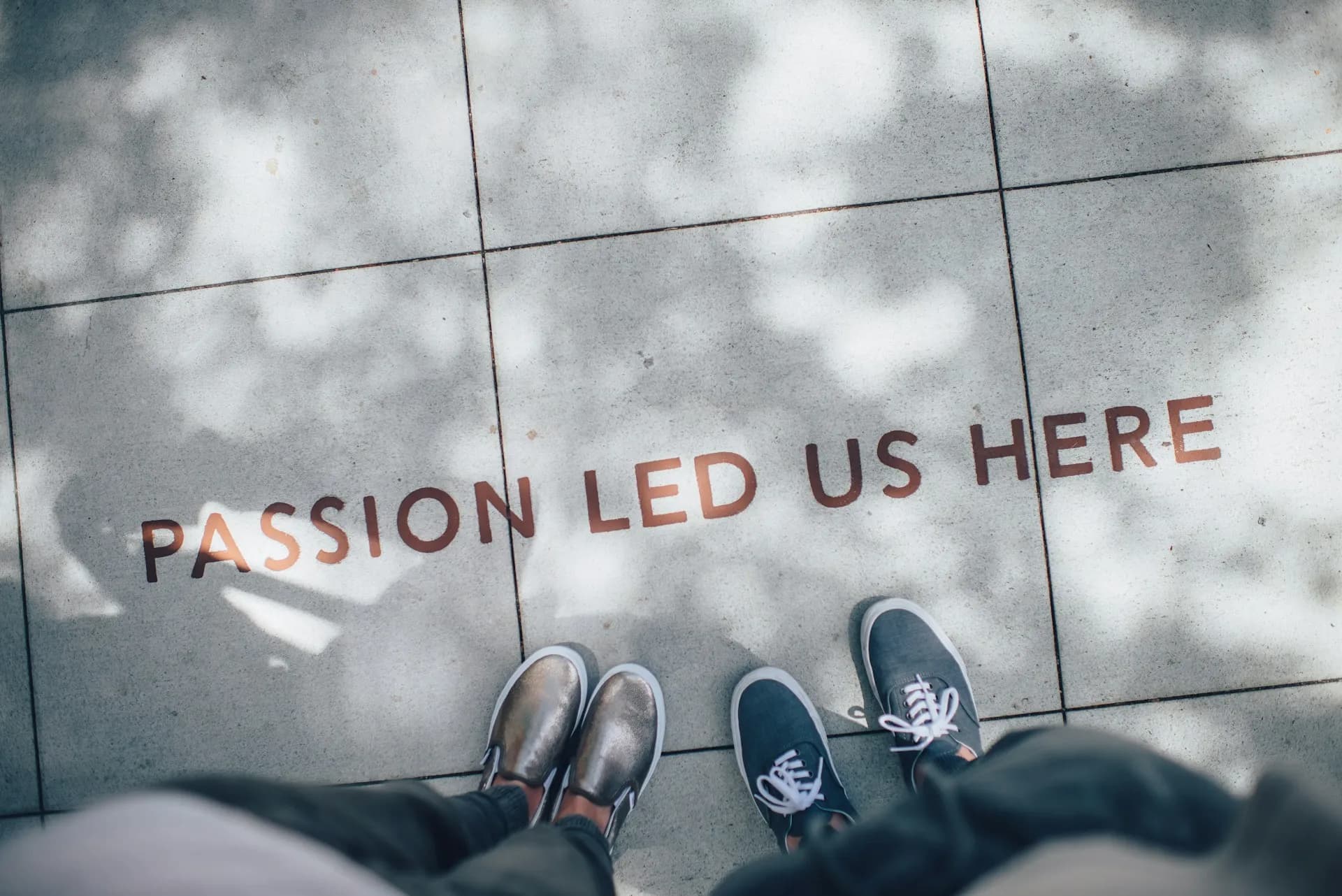 Two feets with shoes on and text passion led us here