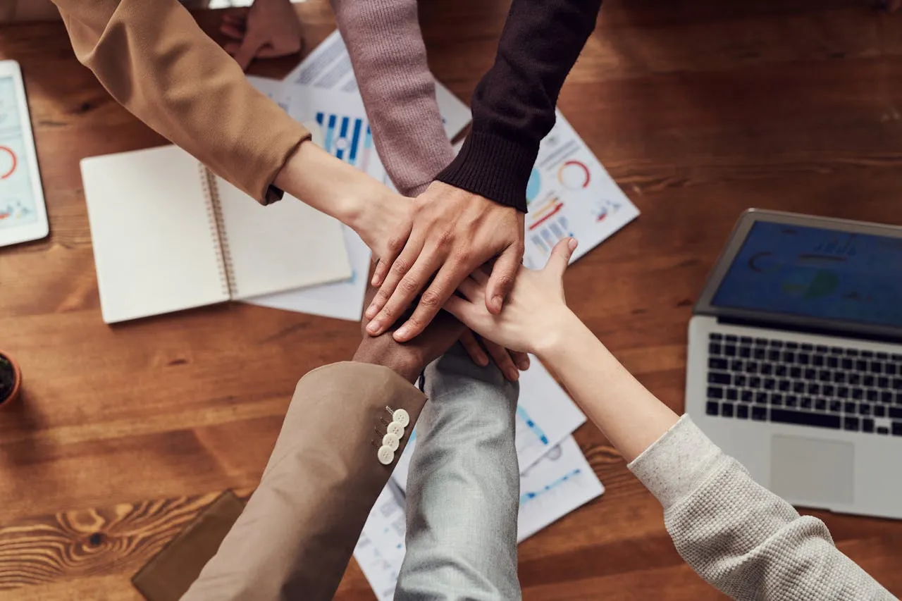 Hands overlapping,  people standing in circle