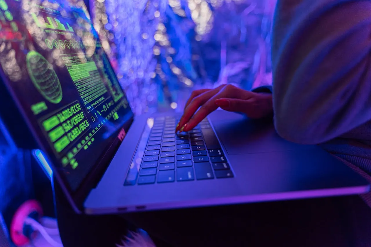 Person using a laptop with neon green text